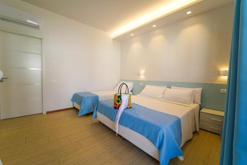 Un dormitorio con dos camas con sábanas azules y blancas. en Resort Acqua di Venere, en Paestum