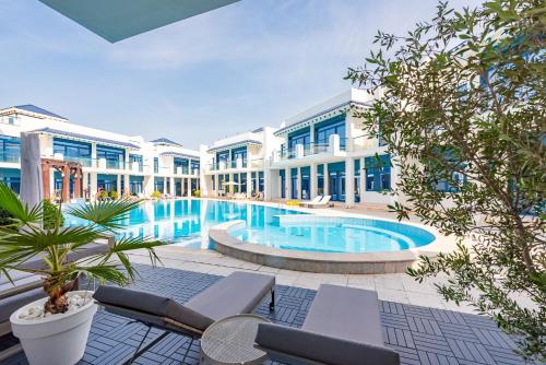 a large swimming pool in front of a building at Stunning Palm Villa with Rooftop Garden, Resort Style Pool and Beach by Exclusive Holiday Homes in Dubai