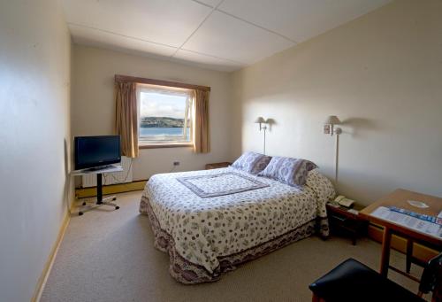 a bedroom with a bed and a television at Hotel de Castro in Castro