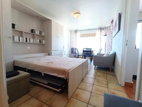 une chambre avec un lit, une table et des chaises dans l'établissement Résidence Montcalm C - Bel appartement avec Piscine et Tennis ! MAE-6624, à Aix-les-Bains