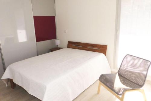 une chambre avec un lit blanc et une chaise dans l'établissement Résidence Terrasses Des Thermes - Belles Prestations pour ce joli 2 pièces ! à deux pas des Thermes ! MAE-6634, à Aix-les-Bains