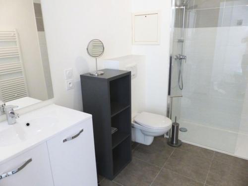 La salle de bains est pourvue de toilettes et d'une douche avec un miroir. dans l'établissement Résidence Terrasses Des Thermes - Belles Prestations pour ce joli 2 pièces ! à deux pas des Thermes ! MAE-6634, à Aix-les-Bains