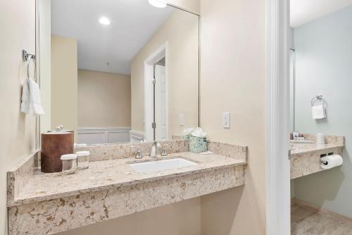 W łazience znajduje się umywalka i lustro. w obiekcie Sag Harbor Inn w mieście Sag Harbor