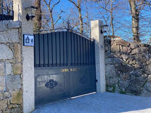 a gate to a house with a stone wall at CASA TAPADA DA CHEDA 2 in Celorico de Basto