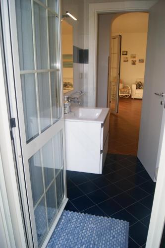 uma casa de banho com um lavatório e uma cabina de duche em vidro. em Villa Milena em Marzamemi