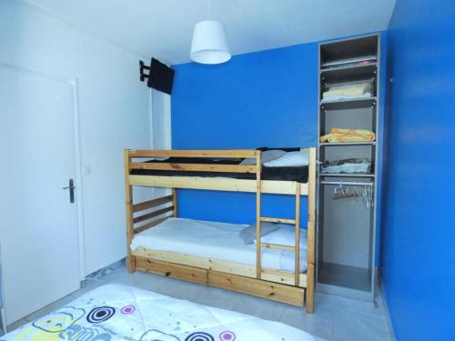 Cette chambre comprend 2 lits superposés et un mur bleu. dans l'établissement Résidence Les Roseaux - Agréable 2 pièces au calme au bord du lac ! MAE-6784, à Aix-les-Bains