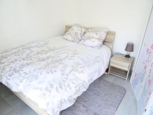 - une chambre avec un lit blanc et une table de nuit dans l'établissement Résidence Le Bachelard - Logement hyper centre, moderne ! MAE-6814, à Aix-les-Bains