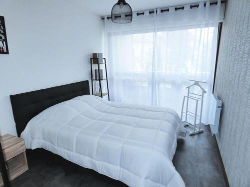 une chambre avec un lit blanc et une fenêtre dans l'établissement Résidence Le Chateau Durieux 1 - Coup de coeur pour ce bel appartement de standing ! MAE-6864, à Aix-les-Bains