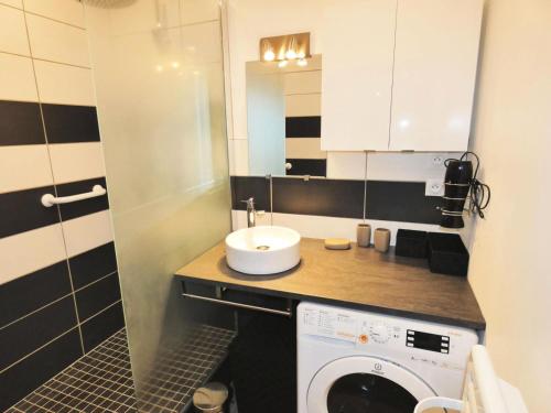 une salle de bain avec une machine à laver et un lavabo dans l'établissement Résidence Le Chateau Durieux 1 - Coup de coeur pour ce bel appartement de standing ! MAE-6864, à Aix-les-Bains
