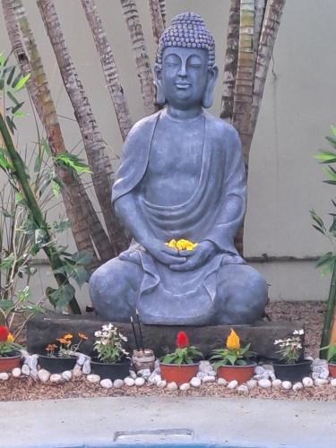 a statue of a buddha sitting in a garden at Explora Prestige in Blue Bay