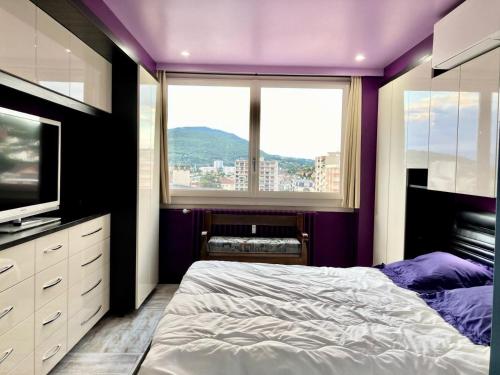 une chambre violette avec un lit et une fenêtre dans l'établissement Résidence Le Constellation - Très fonctionnel pour ce joli appartement ! MAE-6614, à Aix-les-Bains