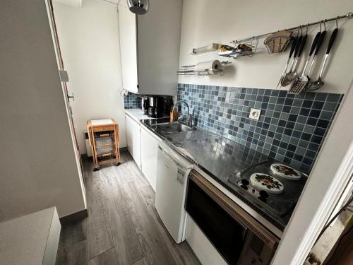 une petite cuisine avec un évier et une cuisinière dans l'établissement Résidence Les Cygnes - Paisible studio au bord du lac ! MAE-6674, à Aix-les-Bains