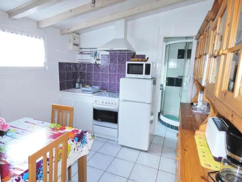 une cuisine avec un réfrigérateur blanc et une table dans l'établissement Résidence 12 Chemin De Chevaline - Agréable logement au calme sur les hauteurs de la ville ! MAE-7104, à Aix-les-Bains