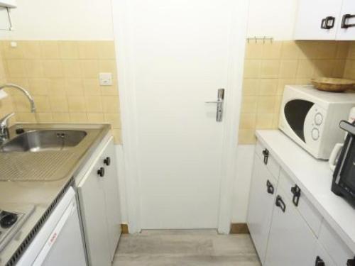 une petite cuisine avec un évier et un micro-ondes dans l'établissement Résidence Le Chateau Durieux 4 - Tout confort pour ce studio bien situé ! MAE-6994, à Aix-les-Bains