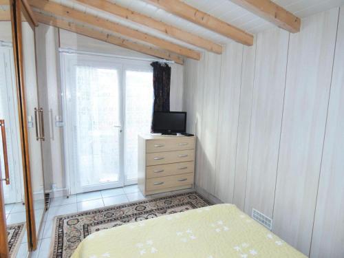 um quarto com uma cama e uma televisão numa cómoda em Résidence 12 Chemin De Chevaline - Studio pour 2 Personnes 104 em Aix-les-Bains