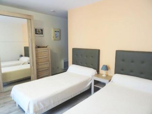 une chambre avec deux lits et un miroir dans l'établissement Résidence Le Chateau Durieux 4 - Tout confort pour ce studio bien situé ! MAE-6994, à Aix-les-Bains