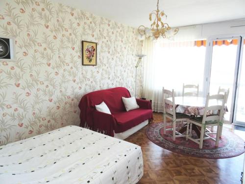 een slaapkamer met een bed, een stoel en een tafel bij Résidence Le Cheverny - Studio pour 2 Personnes 134 in Aix-les-Bains