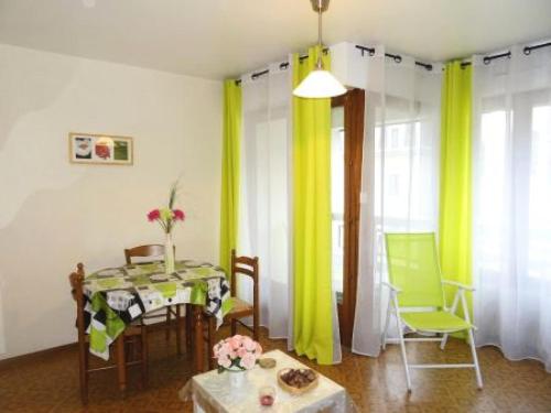 - une salle à manger avec une table, des chaises et des rideaux jaunes dans l'établissement Résidence Le Chateau Durieux 4 - Ravisant et paisible studio 2 personnes ! MAE-7114, à Aix-les-Bains