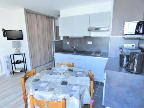 Il comprend une cuisine avec une table et des chaises. dans l'établissement Résidence Le Chateau Durieux 2 - Studio proche commerces ! MAE-7214, à Aix-les-Bains