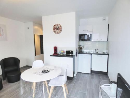 une petite cuisine avec une table et des chaises blanches dans l'établissement Résidence Le Chateau Durieux 3 - Joli petit studio 2 personnes ! MAE-7354, à Aix-les-Bains