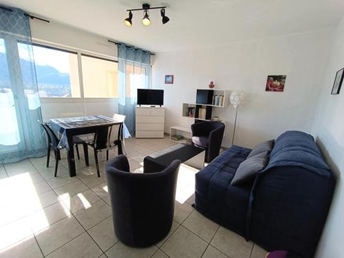 un salon avec un canapé bleu et une table dans l'établissement Résidence Saint Christophe - Logement traversant, agréable et lumineux à 2 pas de la cure ! MAE-7244, à Aix-les-Bains