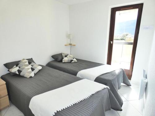 deux lits dans une chambre avec une fenêtre dans l'établissement Résidence Les Colverts - Moderne et lumineux avec belle vue sur le lac ! MAE-7274, à Aix-les-Bains