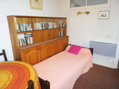 - une chambre avec un lit et une étagère avec des livres dans l'établissement Residence Albion - Agréable logement avec belle vue sur Parc Boisé ! MAE-7514, à Aix-les-Bains