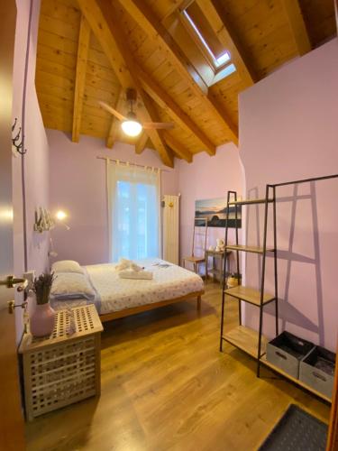 ein Schlafzimmer mit einem Bett in einem Zimmer mit Holzdecken in der Unterkunft La Casa Del Poeta in Dervio