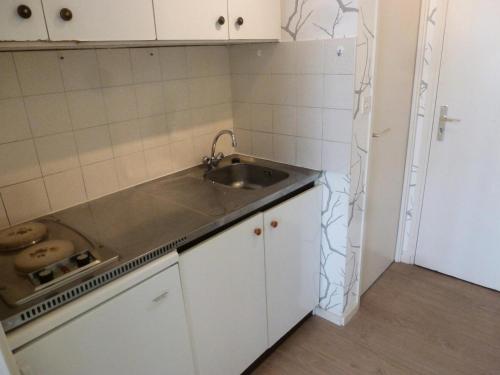 Elle comprend une petite cuisine avec un évier et des placards blancs. dans l'établissement Résidence Saint Christophe - Sur les hauteurs de la ville, Ravisant studio ! MAE-7644, à Aix-les-Bains
