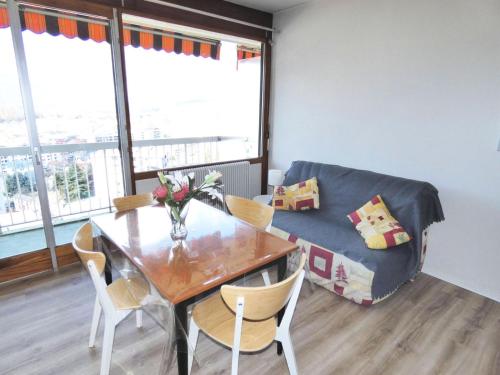 une salle à manger avec une table et un canapé dans l'établissement Résidence Le Cheverny - Proche Parc Boisé, agréable appartement 2 personnes ! MAE-7664, à Aix-les-Bains