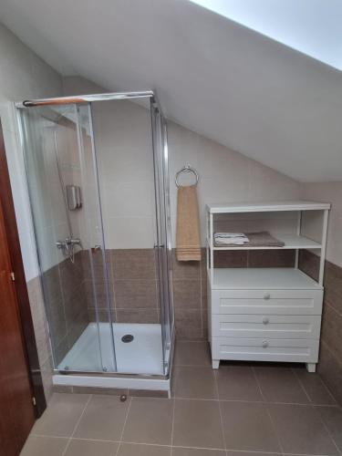 baño con ducha y armario blanco en Romántico apartamento con terraza y piscina, en Villabáñez