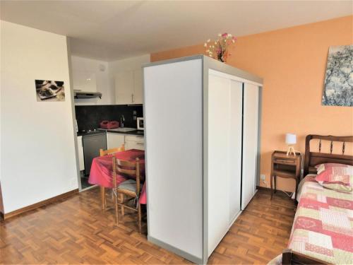 - un salon avec une armoire blanche et une table dans l'établissement Résidence Le Chateau Durieux 3 - Très belle vue pour ce petit studio au calme ! MAE-7724, à Aix-les-Bains