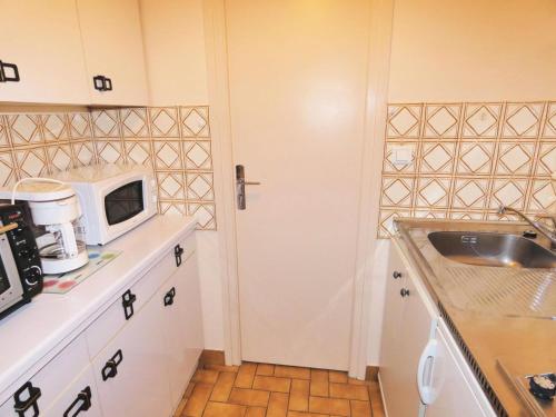 une cuisine avec un évier et un micro-ondes dans l'établissement Résidence Le Chateau Durieux 4 - Vue agréable pour ce studio tout confort ! MAE-7734, à Aix-les-Bains