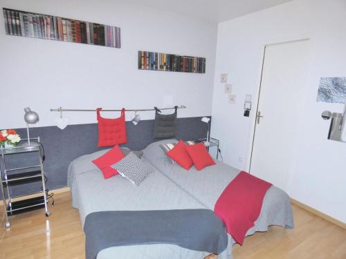 - une chambre avec un lit doté d'oreillers rouges et gris dans l'établissement Résidence Le Saint Charles A - Studio agréable et moderne à 50m des Thermes Chevalley ! MAE-7444, à Aix-les-Bains