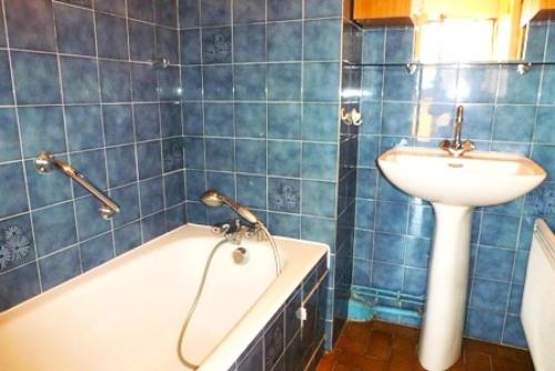 La salle de bains est pourvue de carrelage bleu, d'une baignoire et d'un lavabo. dans l'établissement Résidence Saint Christophe - Studio agréable et ensoleillé et proche de la cure ! MAE-7764, à Aix-les-Bains