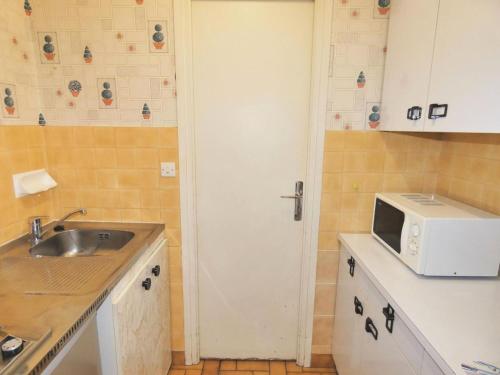 une petite cuisine avec un évier et un micro-ondes dans l'établissement Résidence Le Chateau Durieux 4 - Studio proche tous commerces, fonctionnel ! MAE-7484, à Aix-les-Bains