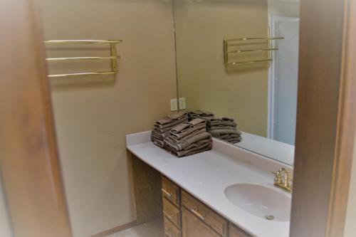 a bathroom with a sink and a mirror at River Hideout: One Bedroom Duplex Cottage ON THE RIVER!! in Ruidoso