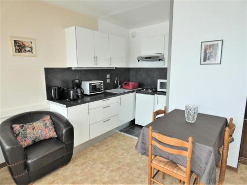 une petite cuisine avec une table et une chaise dans l'établissement Résidence Le Chateau Durieux 3 - Studio bien agencé, proche tous commerces ! MAE-7544, à Aix-les-Bains