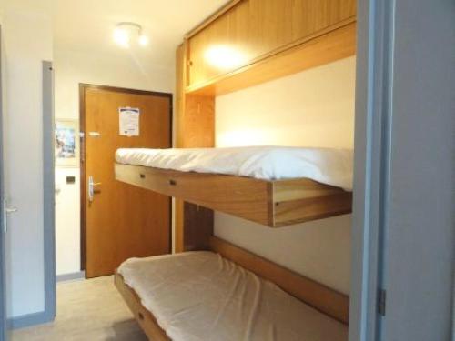 Cette chambre comprend 2 lits superposés et une porte. dans l'établissement Résidence Les Hirondelles - Idéal pour les vacances, studio pour 4 personnes ! MAE-7854, à Aix-les-Bains
