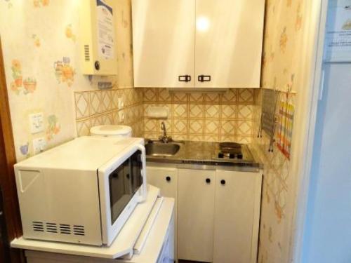 une petite cuisine avec un micro-ondes et un évier dans l'établissement Résidence Le Chateau Durieux 4 - Petit studo accueillant, proche tous commerces ! MAE-7714, à Aix-les-Bains