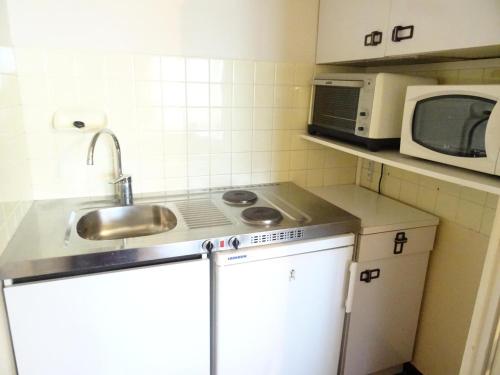une petite cuisine avec un évier et un micro-ondes dans l'établissement Résidence Le Chateau Durieux 3 - Au calme et spacieux studio ! MAE-7744, à Aix-les-Bains