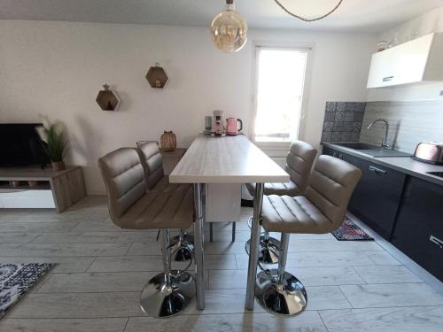 une cuisine avec une table et des chaises dans une pièce dans l'établissement Résidence La Cerisaie - Coquet pour ce joli 2 pièces ! MAE-7004, à Aix-les-Bains