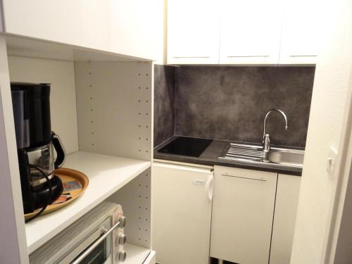 une petite cuisine avec un évier et un micro-ondes dans l'établissement Résidence 21 Rue Des Bains - Dans zone piétonne pour ce petit logement très agréable ! MAE-7794, à Aix-les-Bains