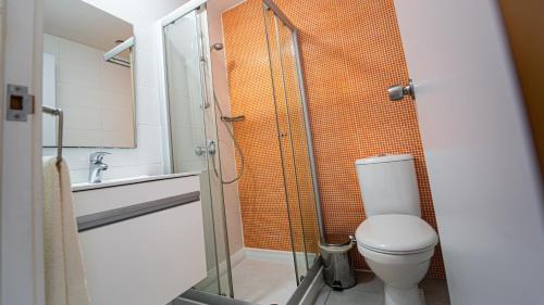 a bathroom with a toilet and a glass shower at UC Hall Residence in Nicosia