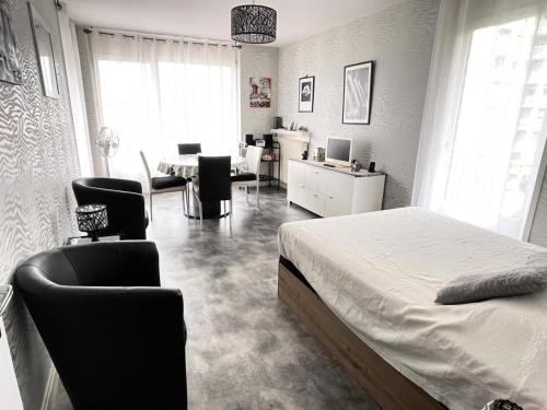 une chambre avec un lit, une table et des chaises dans l'établissement Résidence Montcalm D - Agréable logement et bien équipé ! MAE-2174, à Aix-les-Bains