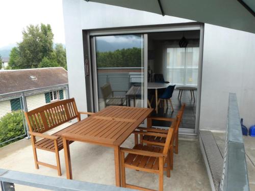 d'une terrasse avec une table et des chaises en bois sur un balcon. dans l'établissement Résidence Villa Neree - Charmant appartement au Bord du Lac ! MAE-2924, à Aix-les-Bains