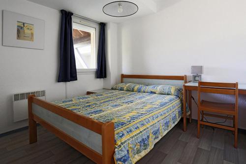 1 dormitorio con cama, escritorio y ventana en Résidence Balcons Du Soleil - Pièces 954, en Germ