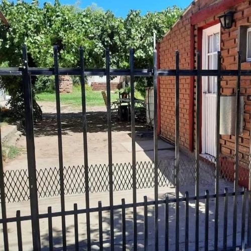 a black fence in front of a brick building at Cabañas Millaray in Huinganco