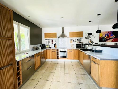 une grande cuisine avec des placards en bois et un grand îlot dans l'établissement Villa Cosy - Villa de vacances environnement calme MAE-4054, à La Grande Motte
