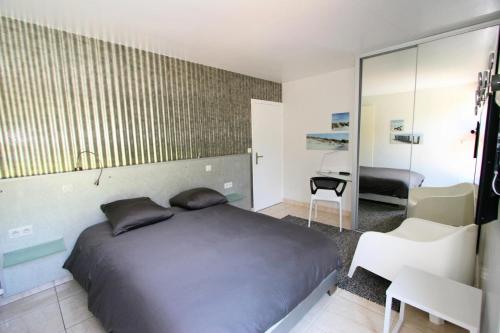une chambre avec un lit, un bureau et un miroir dans l'établissement Villa Golf - villa unique en première ligne sur le golf MAE-4044, à La Grande Motte
